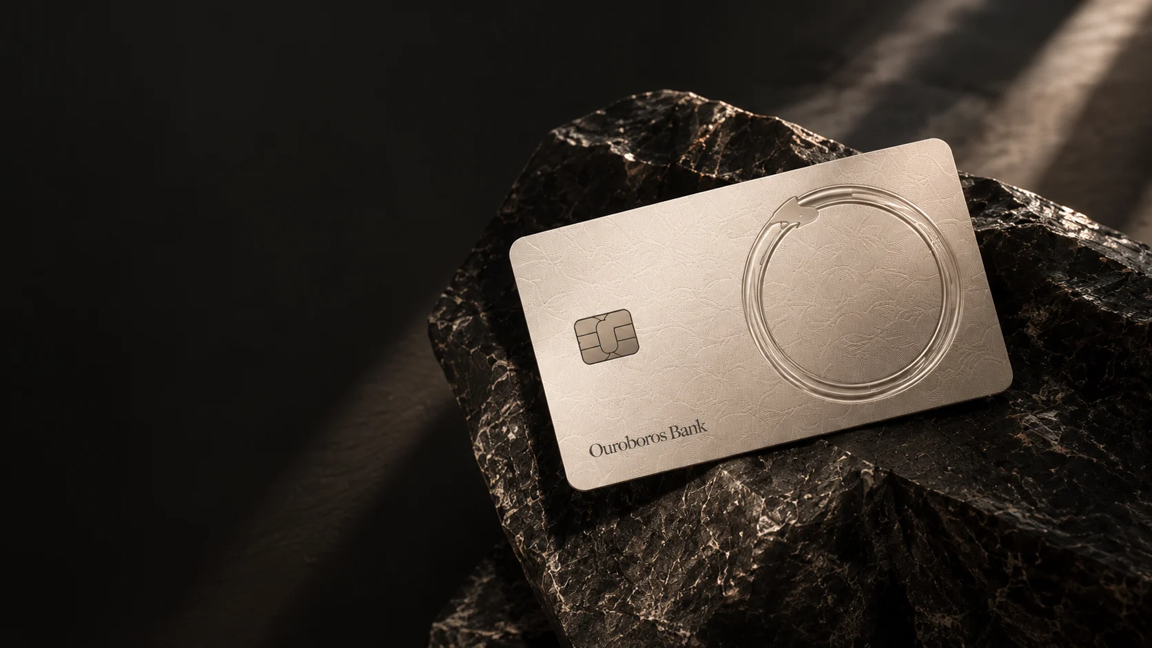 Illustrative champagne Ouroboros card resting on dark sculptural stone